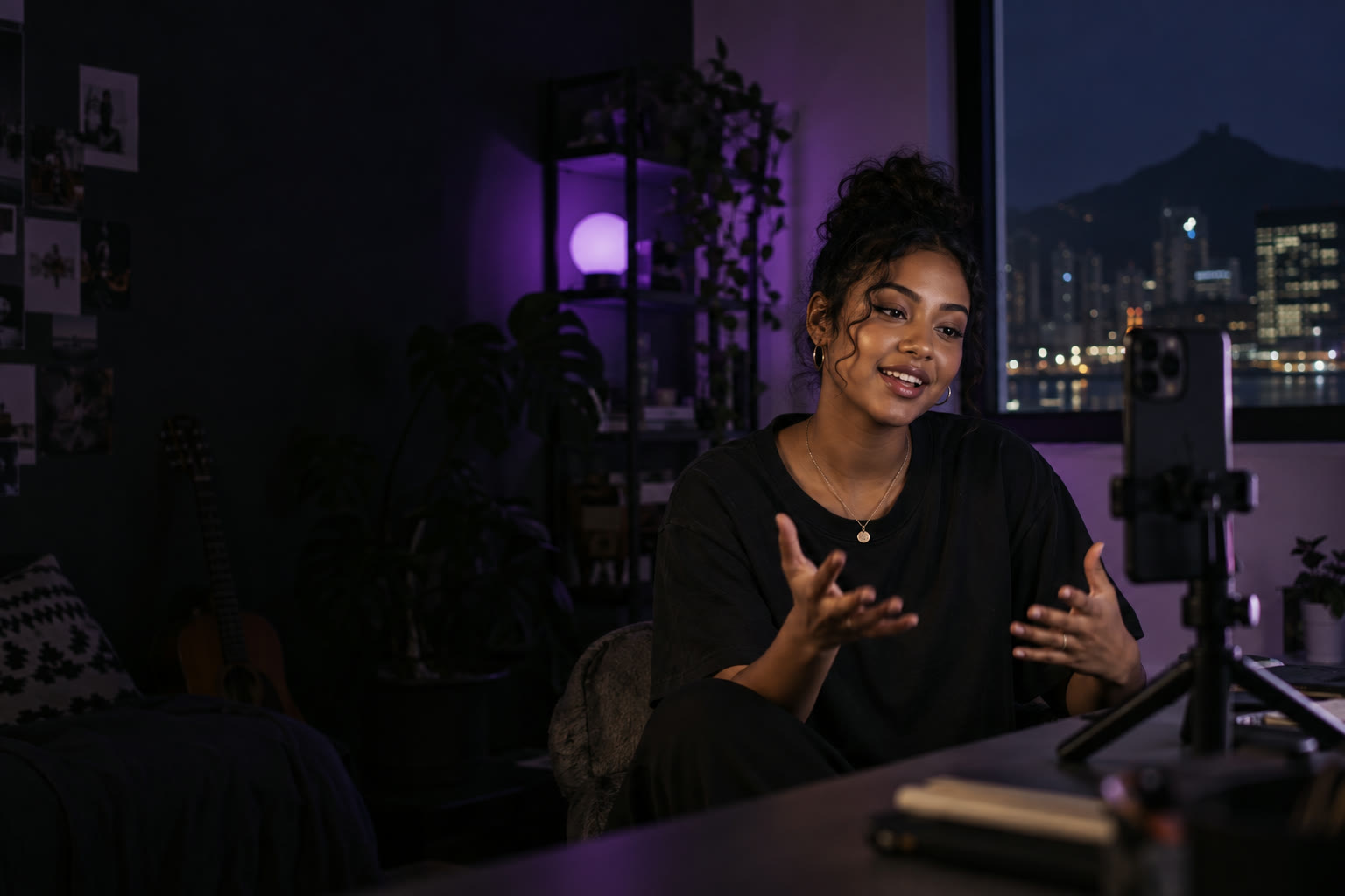 Creator filming a vertical video on a phone in a small home studio at night